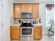 View of stainless steel range, microwave, and wood cabinets at 426 Orange Cosmos Blvd, Davenport, FL 33837