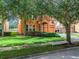 Two-story house with orange exterior, two-car garage, and lush landscaping at 426 Orange Cosmos Blvd, Davenport, FL 33837