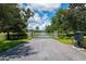 Gated entrance to a community with a paved road and landscaping at 26012 Splendid Meadow Ct, Astatula, FL 34705