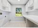 Laundry room with built-in cabinetry and a large window at 26012 Splendid Meadow Ct, Astatula, FL 34705