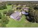 Aerial view of a home with pool and detached building, surrounded by lush greenery at 26012 Splendid Meadow Ct, Astatula, FL 34705