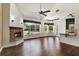 Open living area showcasing a stone fireplace, hardwood floors, and backyard views at 26012 Splendid Meadow Ct, Astatula, FL 34705
