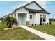 Charming one-story home with light blue siding, stone accents, and a covered porch at 10643 Grand Oaks Blvd, Oxford, FL 34484