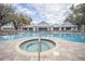 Resort-style pool and spa with a large deck and clubhouse view at 10593 Grand Oaks Blvd, Oxford, FL 34484