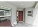 Front porch with seating, red door and view of the neighborhood at 2968 Wotring Way, The Villages, FL 32163