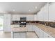 Modern kitchen featuring white cabinets and granite countertops at 2968 Wotring Way, The Villages, FL 32163