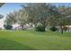Large backyard with lush green grass and mature trees at 21701 Queen Mary Ct, Leesburg, FL 34748