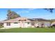Single-story home with pink accents and green lawn at 21701 Queen Mary Ct, Leesburg, FL 34748