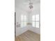 Spacious bedroom with two windows, wood-look flooring, and ceiling fan at 21701 Queen Mary Ct, Leesburg, FL 34748