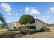 Landscaped yard with a tan house and two-car garage at 15300 Sw 14Th Avenue Rd, Ocala, FL 34473