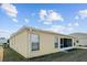 Rear view of a tan house with a screened porch and windows at 15300 Sw 14Th Avenue Rd, Ocala, FL 34473