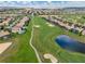 Aerial view of a golf course with a pond and residential homes at 1592 Flange Dr, Davenport, FL 33896