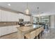 Modern kitchen with granite island, white cabinets, and stainless steel appliances at 1592 Flange Dr, Davenport, FL 33896