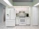 Kitchen with white cabinets, appliances, and tile floor at 5430 Sir Churchill Dr, Leesburg, FL 34748