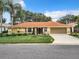Single story home with orange tile roof and palm trees at 5430 Sir Churchill Dr, Leesburg, FL 34748