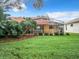 Home's backyard features a large green lawn and screened patio at 5430 Sir Churchill Dr, Leesburg, FL 34748