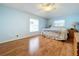 Main bedroom with light blue walls, hardwood floors, and a ceiling fan at 5430 Sir Churchill Dr, Leesburg, FL 34748