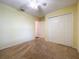 Bedroom with double door closet, ceiling fan and neutral carpeting at 5430 Sir Churchill Dr, Leesburg, FL 34748