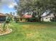 Large backyard with lush green grass and mature trees at 5430 Sir Churchill Dr, Leesburg, FL 34748
