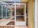 White screened patio door leading to a spacious screened-in patio area at 5430 Sir Churchill Dr, Leesburg, FL 34748