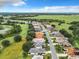 Aerial view showing a neighborhood of homes near a lake and open fields at 5430 Sir Churchill Dr, Leesburg, FL 34748