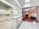 Kitchen features white cabinets, a breakfast bar, and view into living area at 5430 Sir Churchill Dr, Leesburg, FL 34748