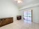 Bonus room featuring sliding doors to a screened patio and wood-look tile floor at 5430 Sir Churchill Dr, Leesburg, FL 34748