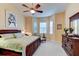 Main bedroom with king bed, window seating, and large dresser at 44 Camino Real Blvd # 44, Howey In The Hills, FL 34737