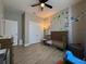 Cozy bedroom with wood-look floors, ceiling fan, and whimsical wall decor at 1316 Water Willow Dr, Groveland, FL 34736