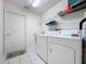 Bright laundry room with washer, dryer and storage shelves at 2112 Saint Ives Ct, Clermont, FL 34711