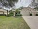 Tan two-story house with three car garage and manicured lawn at 2112 Saint Ives Ct, Clermont, FL 34711