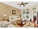 Living room featuring white sofas, a wooden coffee table, and French doors at 5911 Whisper Pine Dr, Leesburg, FL 34748