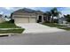 Tan house with three car garage and solar panels at 1316 Water Willow Dr, Groveland, FL 34736