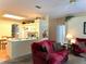 Open Gathering room with a red couch and kitchen view at 2277 Calvert Ct, Clermont, FL 34711
