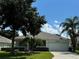 Single-story home with a two-car garage, palm trees, and well-manicured lawn at 2277 Calvert Ct, Clermont, FL 34711