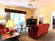 Bright living room features a red couch, sliding glass doors, and views of the patio at 2277 Calvert Ct, Clermont, FL 34711