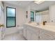 Clean bathroom with white vanity and a large window at 10822 E Revels Rd, Howey In The Hills, FL 34737