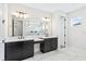 Luxurious bathroom with dual vanities, marble countertops, and dark cabinetry at 15607 Vetta Dr, Montverde, FL 34756