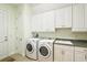 Laundry room with washer, dryer, and cabinets at 9323 San Jose Blvd, Howey In The Hills, FL 34737
