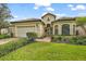 House exterior with two-car garage and landscaping at 9323 San Jose Blvd, Howey In The Hills, FL 34737