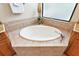 Oval soaking tub with tiled surround in corner bathroom at 9323 San Jose Blvd, Howey In The Hills, FL 34737