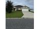 Single-story house with a white garage door and a neatly kept lawn at 608 Bradley Way, Fruitland Park, FL 34731