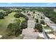 Aerial view of community, showing homes, golf course, and landscaping at 24215 Belle Mede Dr, Leesburg, FL 34748