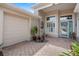 Front entry with a brick walkway, teal door and nicely landscaped area at 24215 Belle Mede Dr, Leesburg, FL 34748