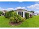 Landscaped backyard with lush green lawn and privacy hedge at 2403 Carriage Hill Way, The Villages, FL 32162