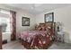 Guest bedroom with floral bedding and ceiling fan at 2403 Carriage Hill Way, The Villages, FL 32162