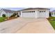 Two-car garage, landscaped yard, and a spacious driveway at 2403 Carriage Hill Way, The Villages, FL 32162