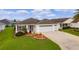 House exterior with a two-car garage and manicured lawn at 2403 Carriage Hill Way, The Villages, FL 32162