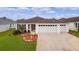 Two-car garage, manicured lawn, and a driveway at 2403 Carriage Hill Way, The Villages, FL 32162