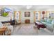 Living room with a large TV, comfortable seating, and a decorative area rug at 2403 Carriage Hill Way, The Villages, FL 32162